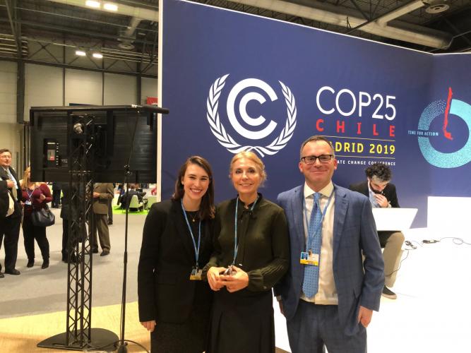 Jocelyn Perry, Koko Warner, and Michael Weisberg standing at the events stage at COP25 in Madrid, December 2019